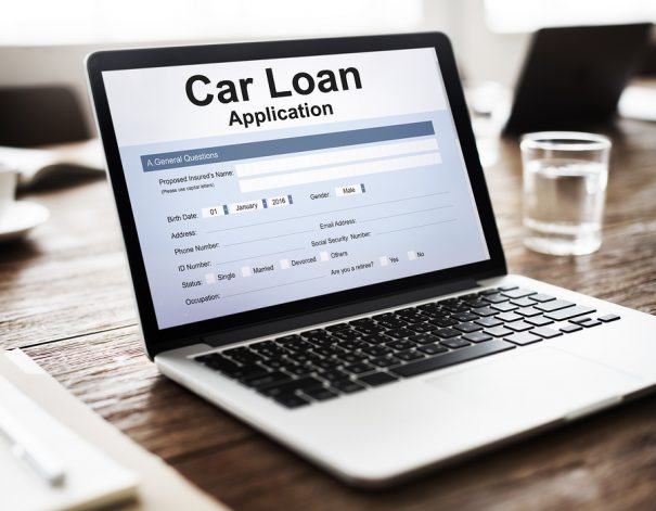 A car loan finance application with money and a pen.