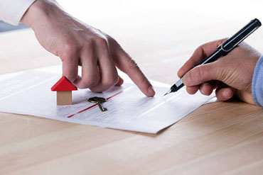 A person reviewing paperwork in the older BillSaver finance-photo style.