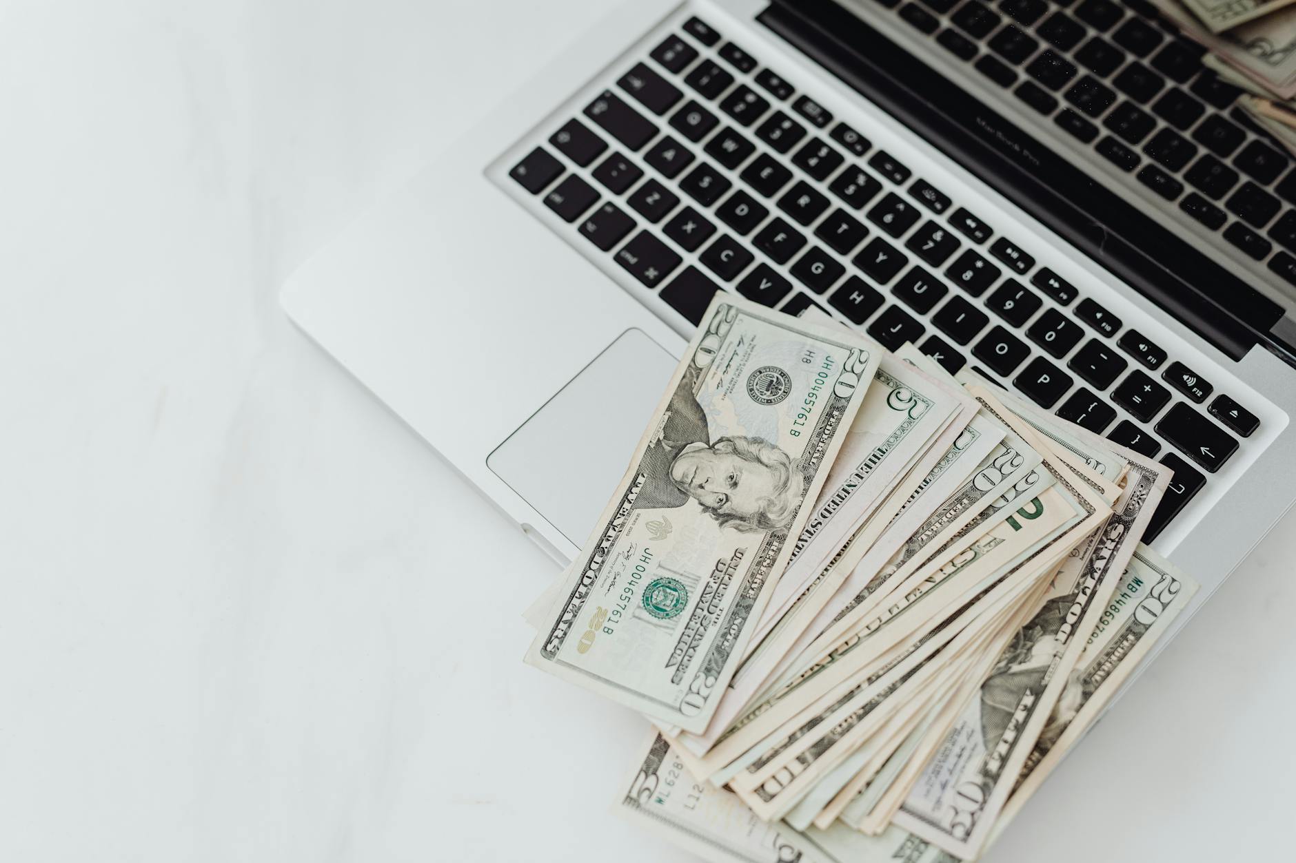 Cash arranged beside a laptop for a move-in cost review.