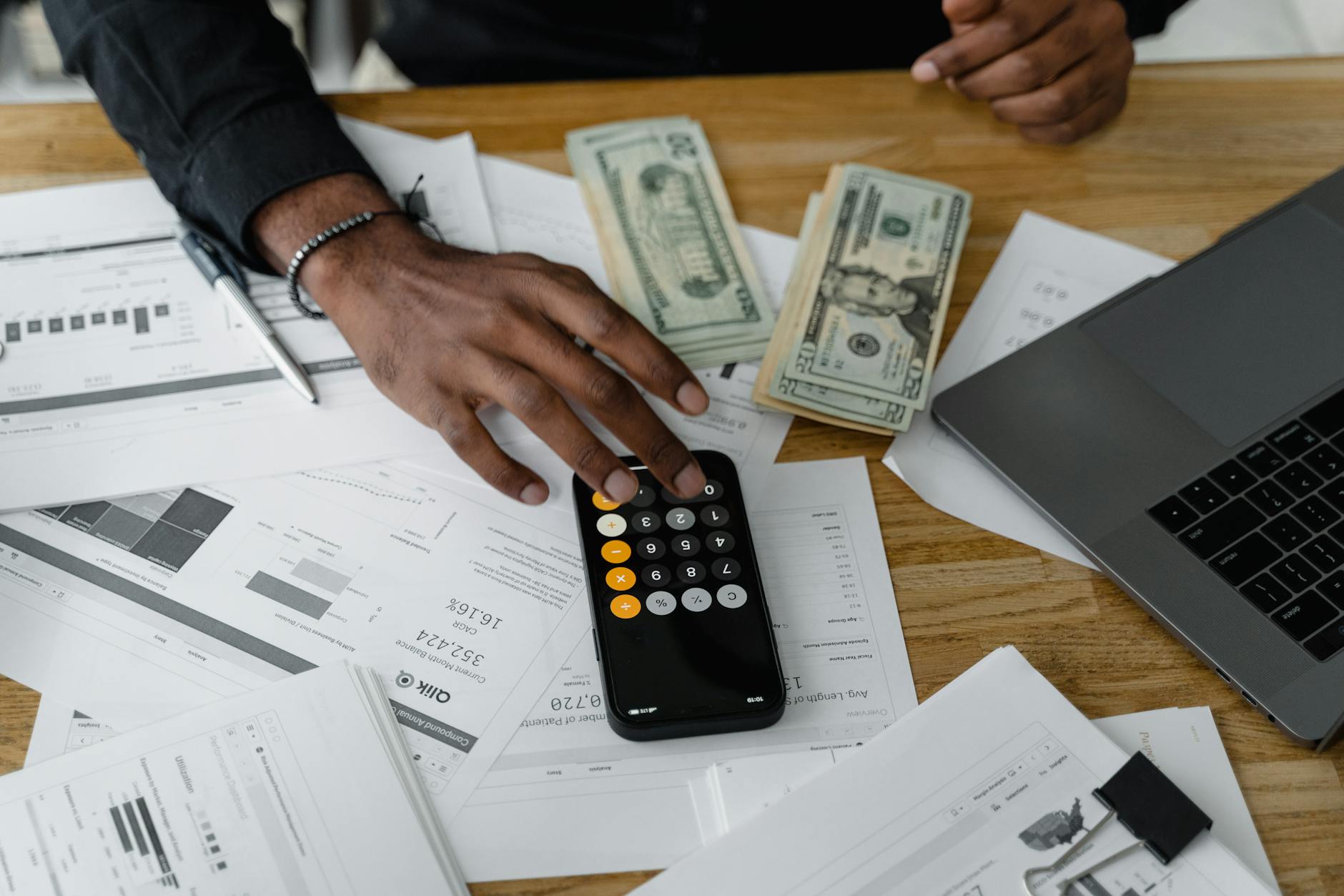 Hands reviewing donation and payment details near cash and a calculator.