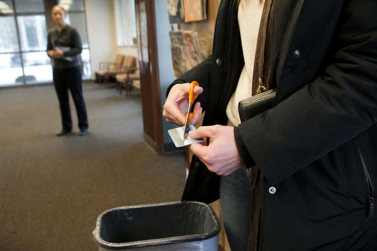 A borrower cutting up an old card after a credit counseling appointment.