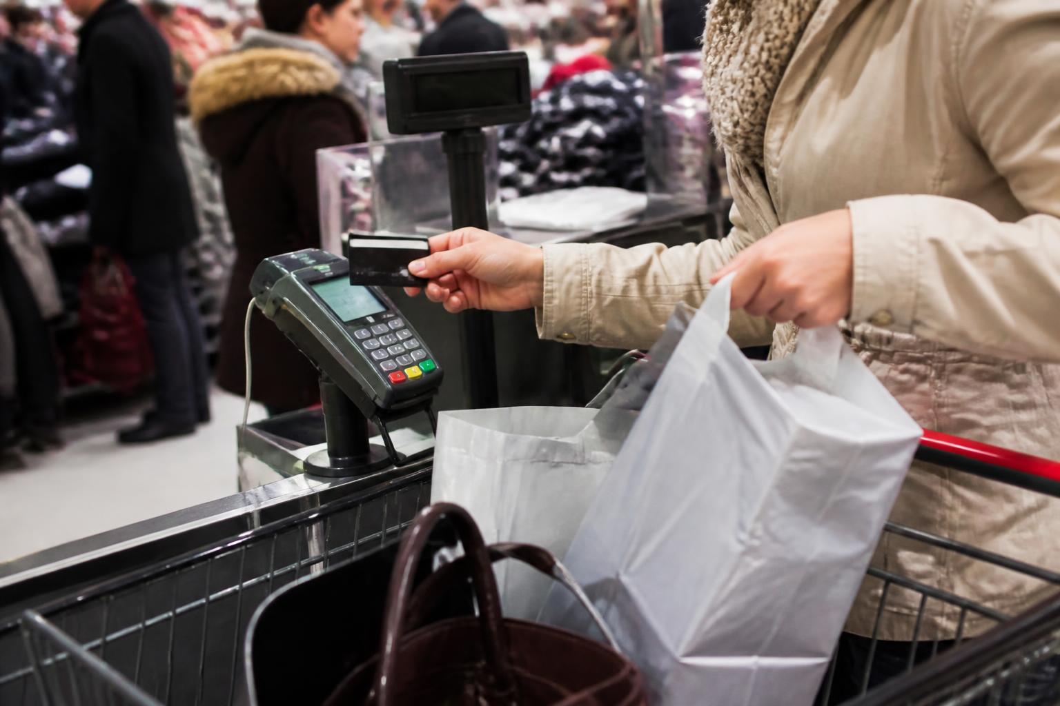A Black Friday shopper using a card at checkout while limiting purchases.