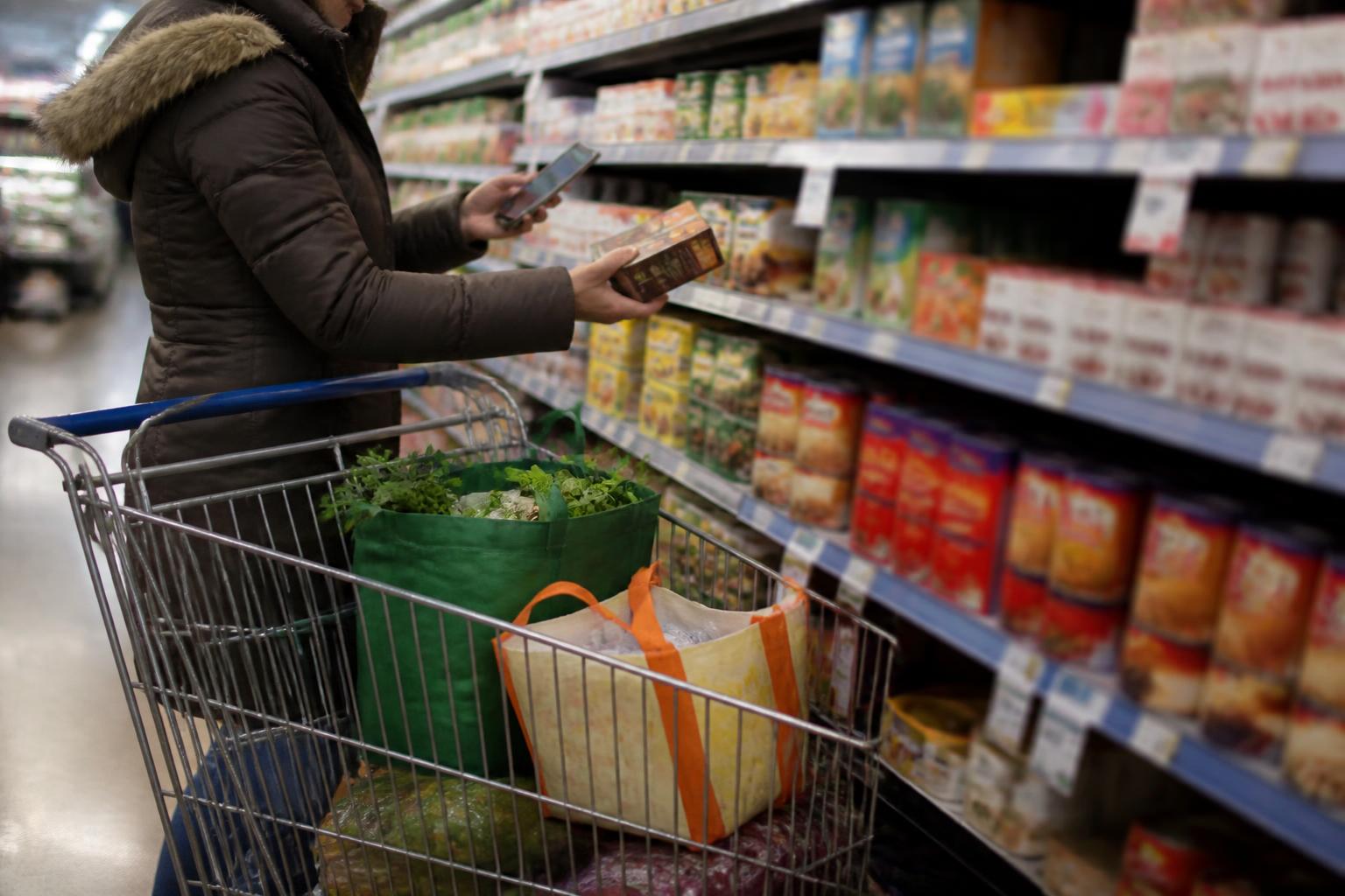 A shopper using a blurred budget screen while putting an item back before 2016.