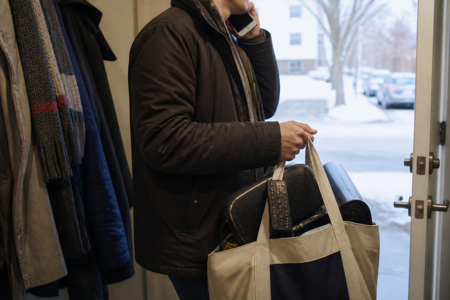 A person carrying unused service equipment while calling a provider during a bill audit.