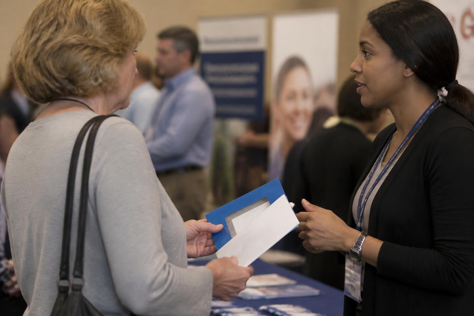 An employee speaking with a benefits representative during open enrollment.