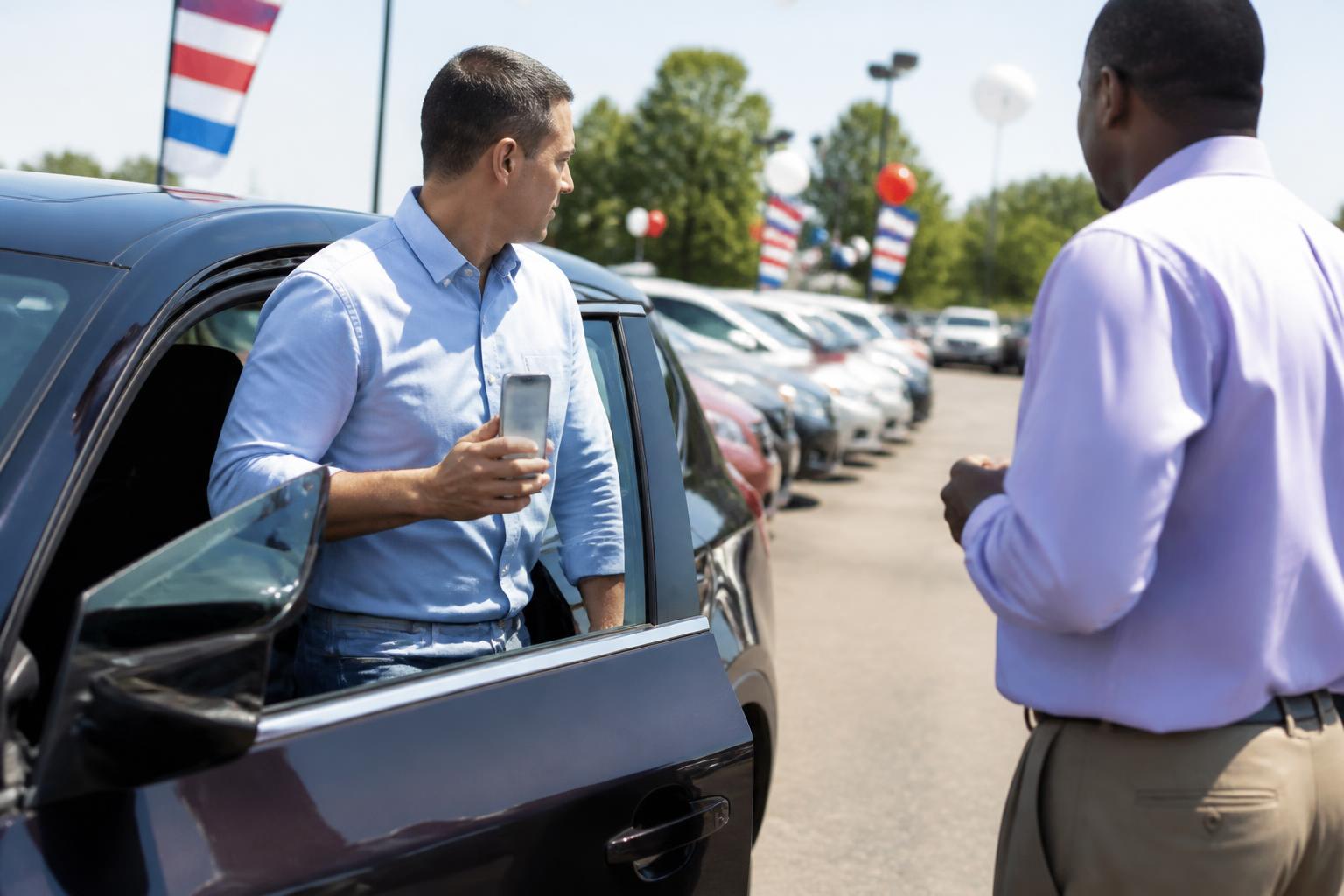 A buyer leaving a test drive while checking a blurred loan app.