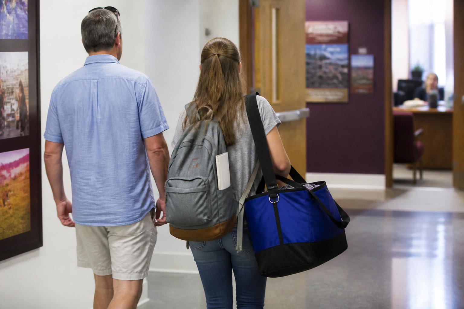 A student and parent leaving an admissions office during deposit season.