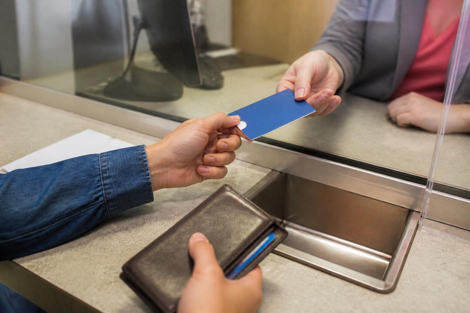 A taxpayer choosing a debit card sleeve at a bank teller window.