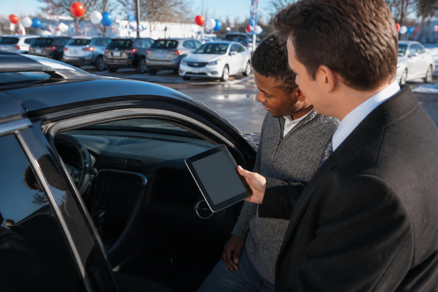 A buyer reviewing auto payment terms on a Presidents Day car lot.