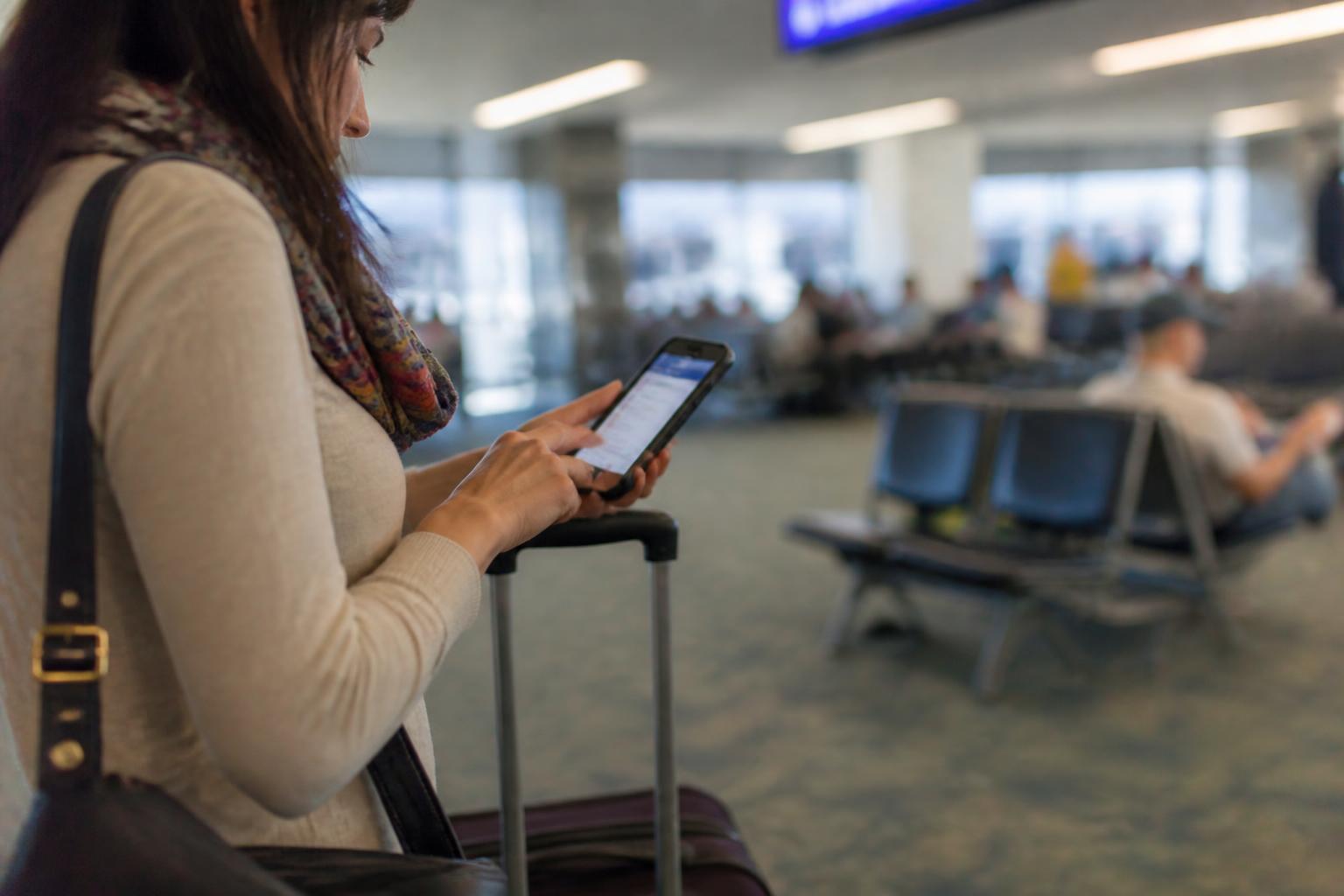 A traveler setting a blurred card alert at an airport gate.