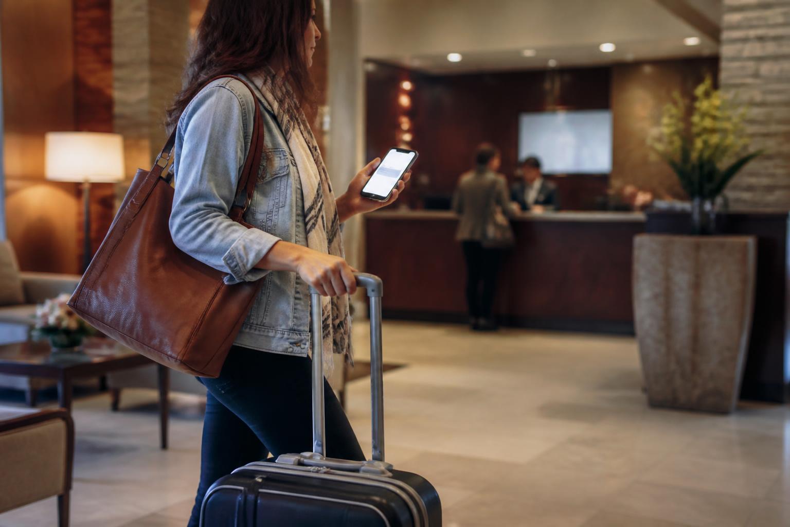 A traveler setting a blurred card alert in a hotel lobby.