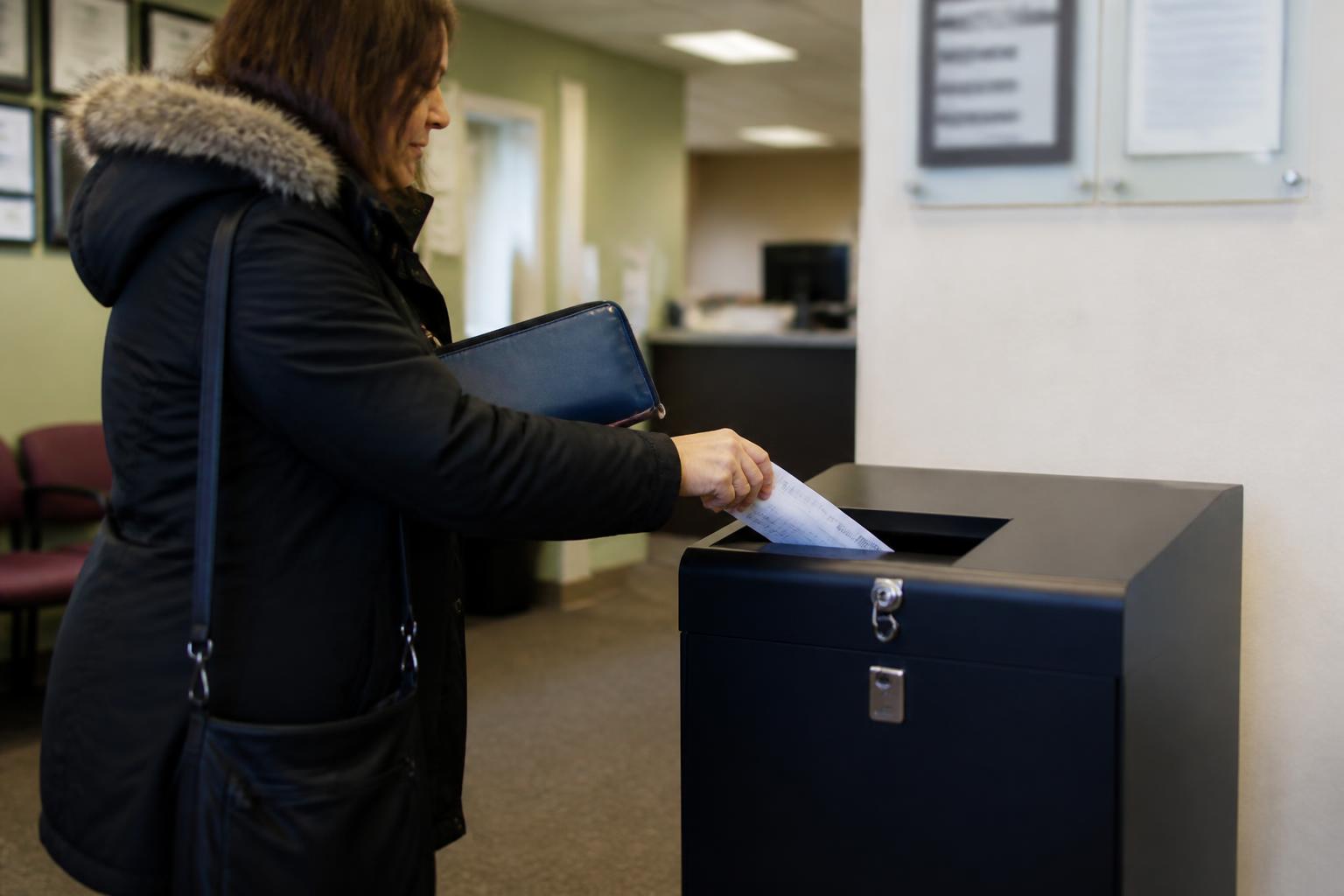 A taxpayer using a locked shred bin during filing season.