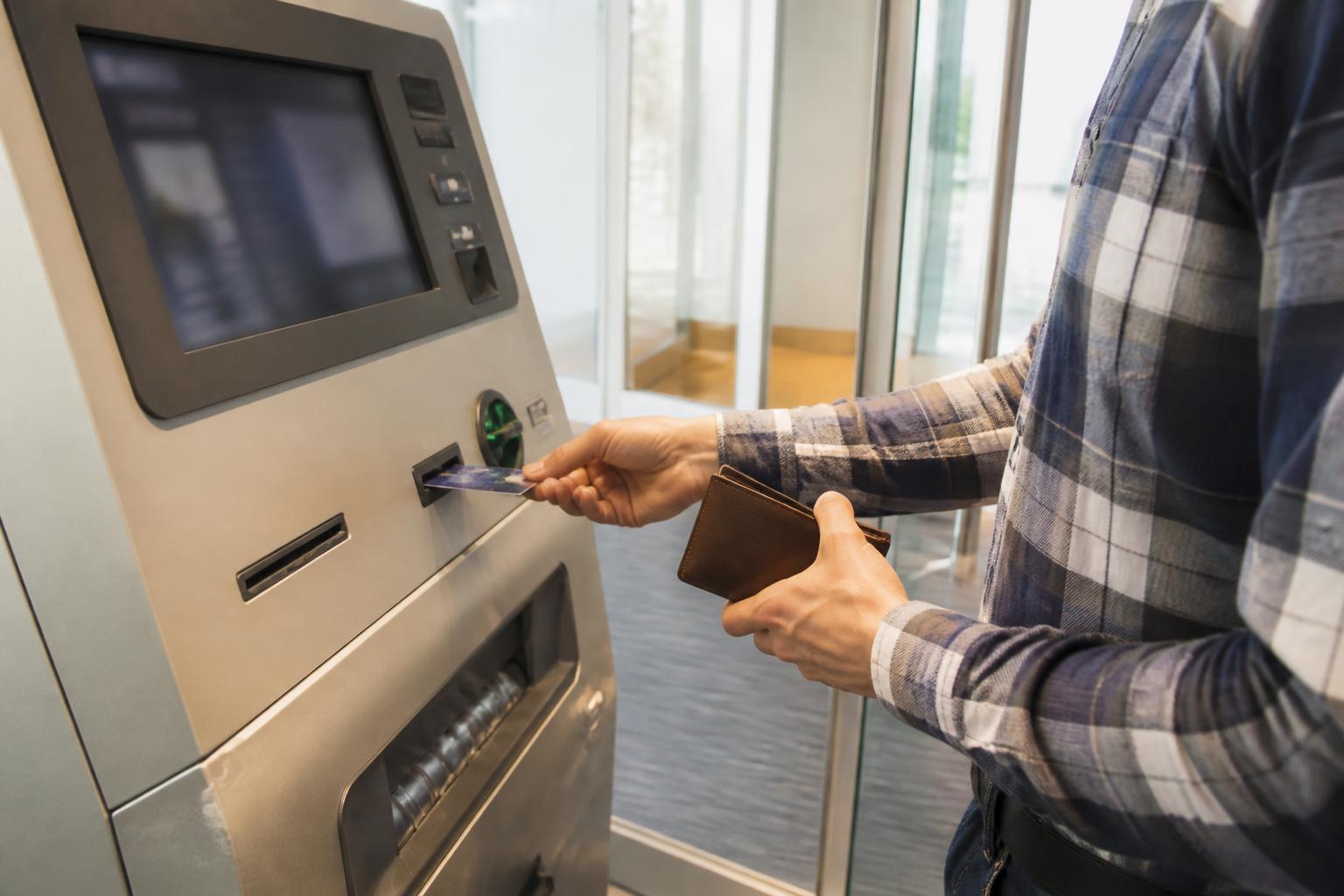 A borrower making an extra payment at a bank kiosk.