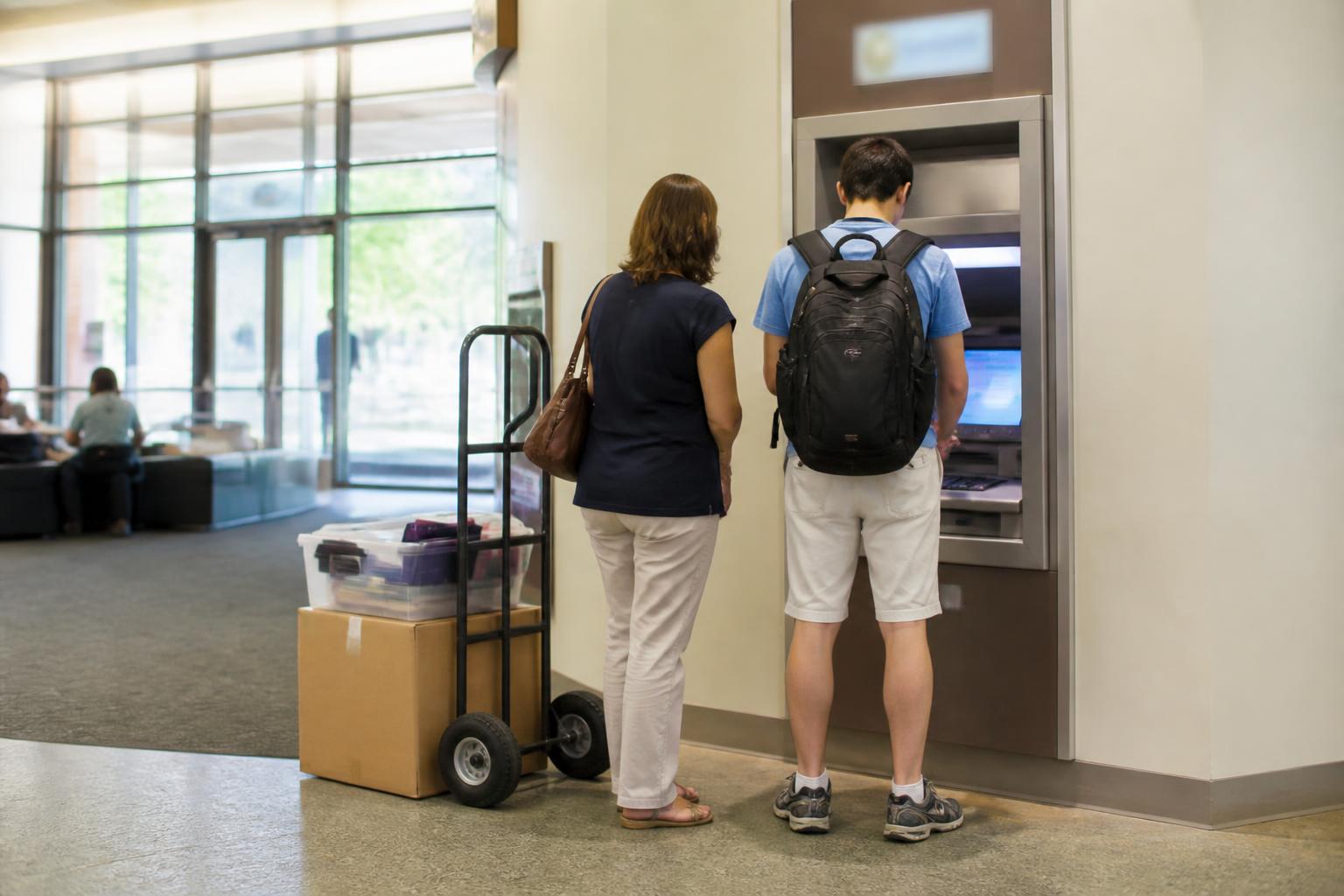 A student and parent choosing a campus ATM before move-in.