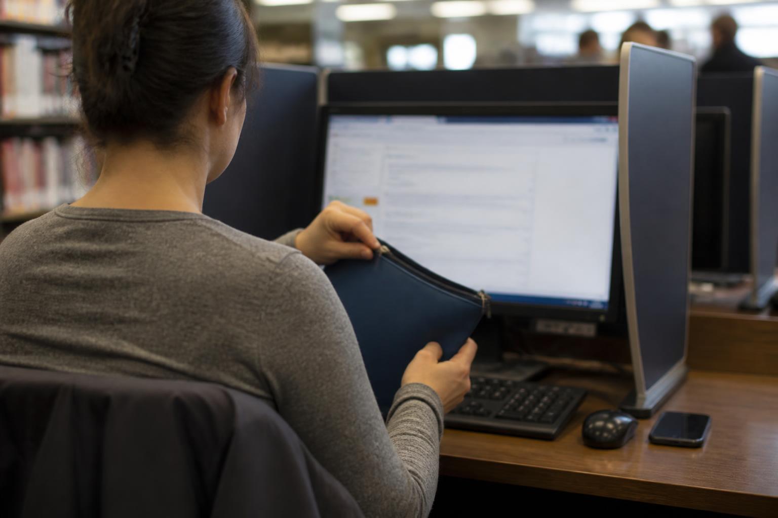 A consumer preparing a credit freeze on a privacy-screen computer.