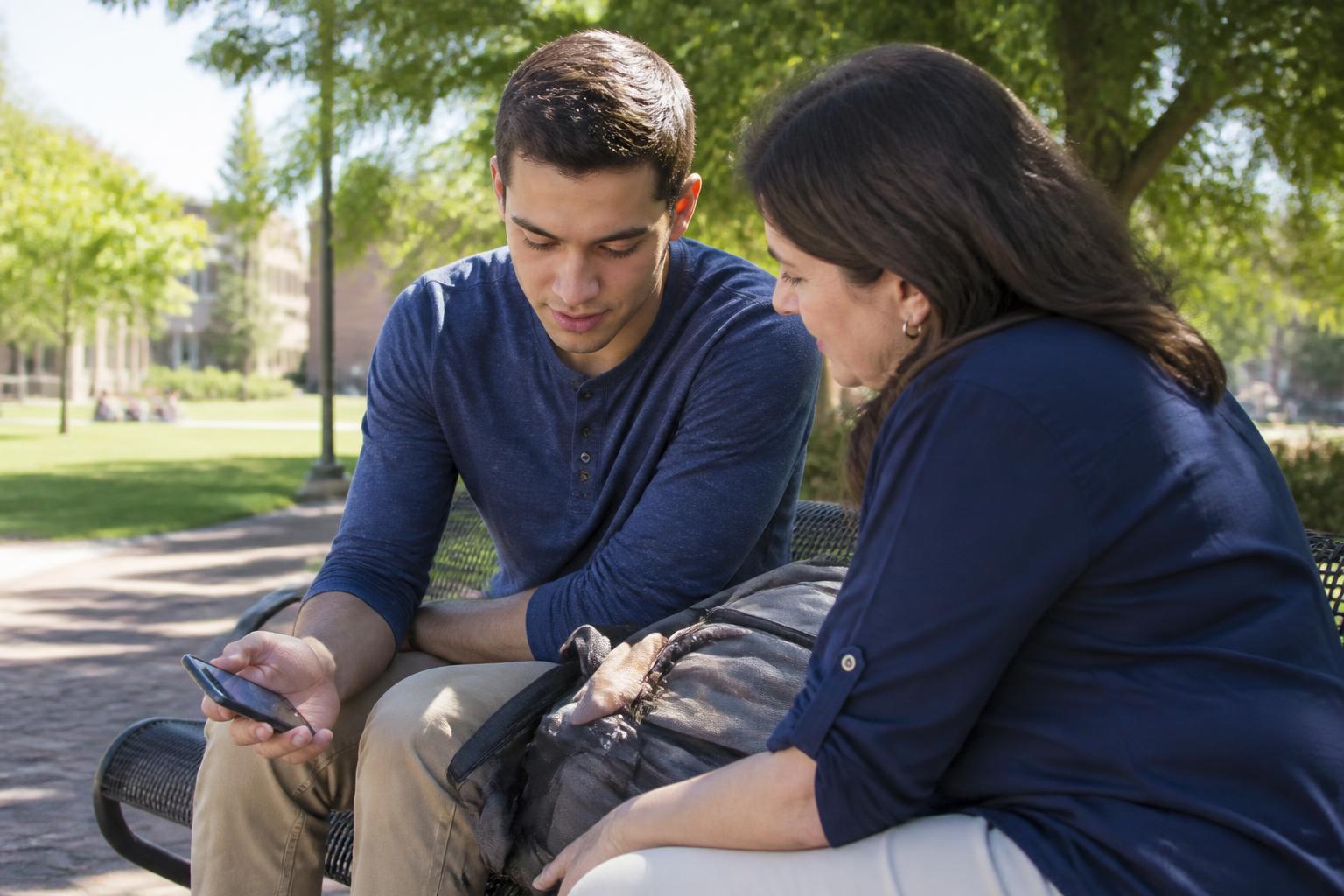 A student and parent comparing a blurred phone calculator with a backpack between them.