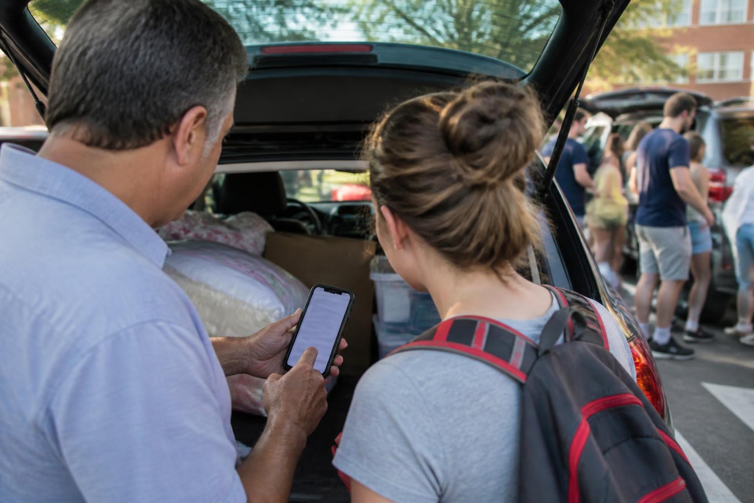 A parent and student setting a card alert during campus move-in.