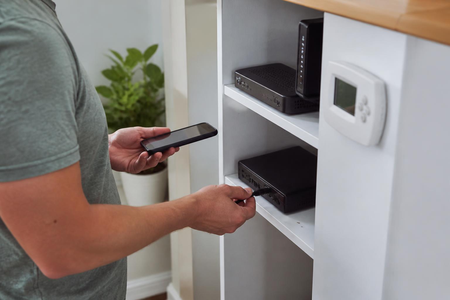 A person unplugging an unused service box during a recurring-bill review.