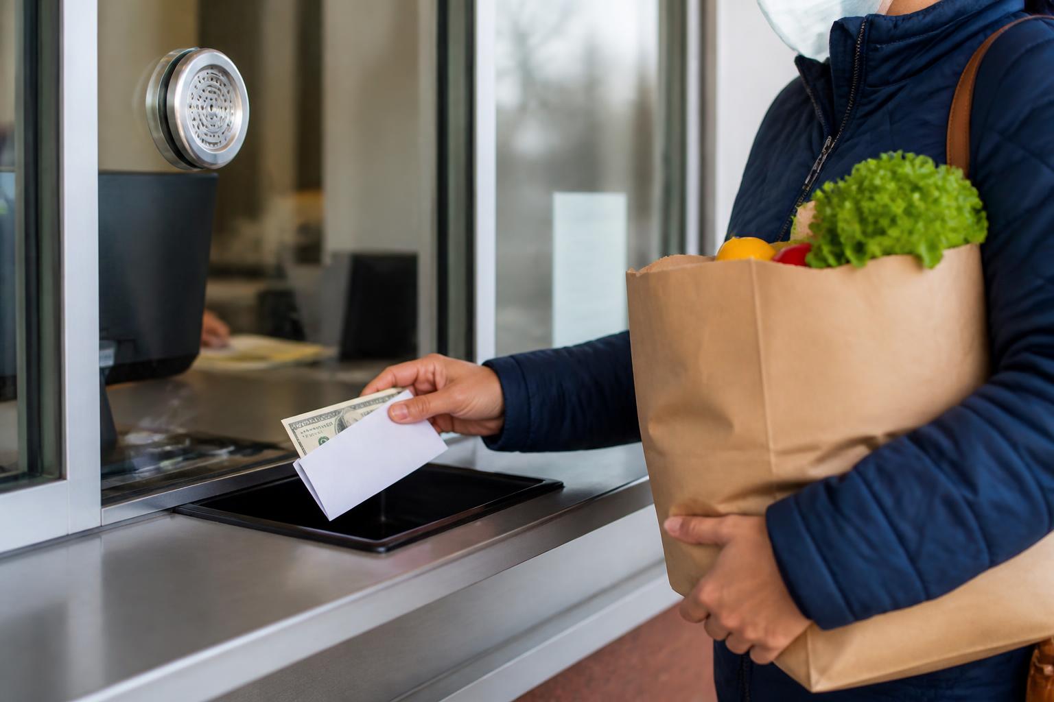 A customer depositing part of a relief payment at a bank service window.
