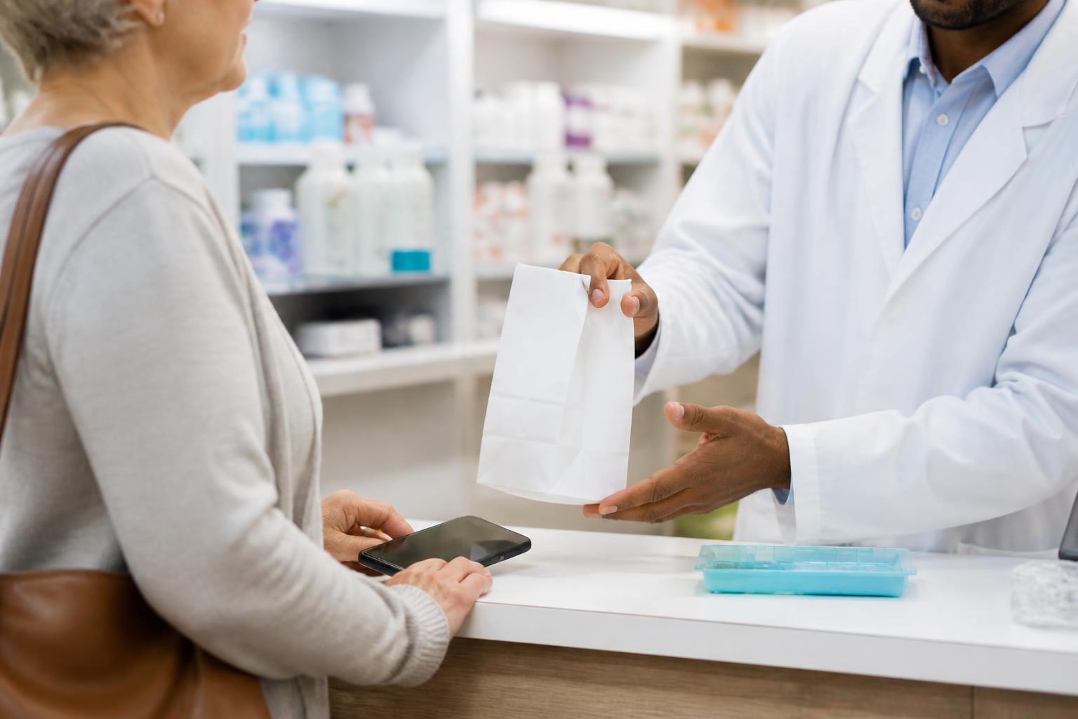 An older adult asking a pharmacist about prescriptions and telehealth.