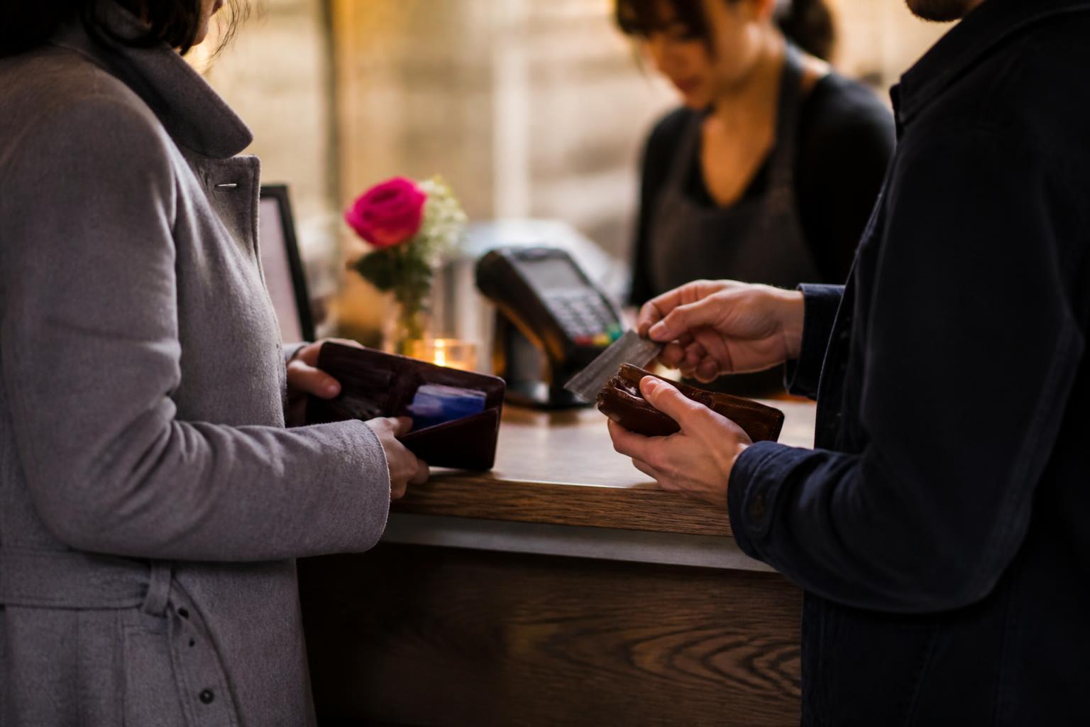 Two partners splitting a restaurant bill during Valentine week.