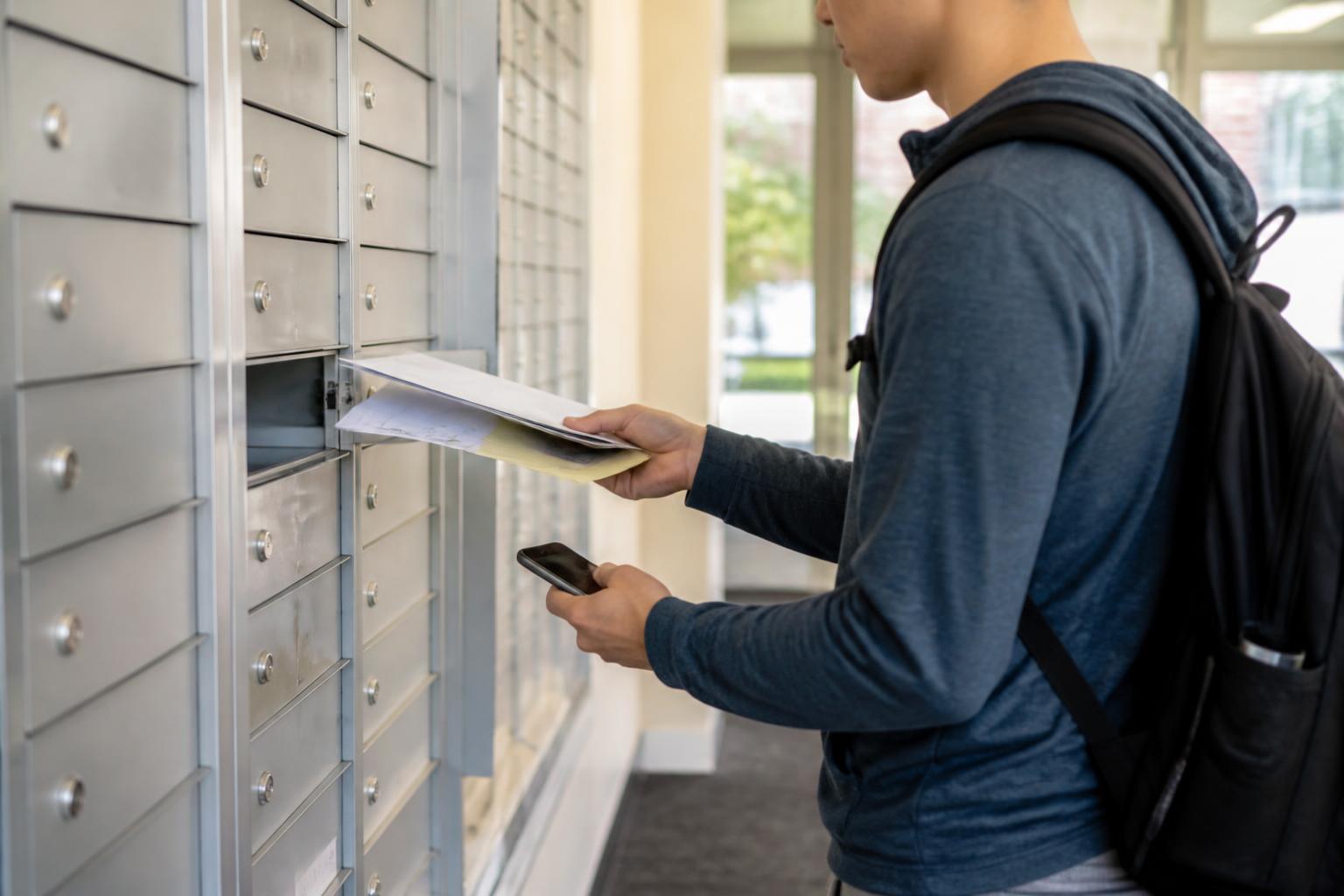 A borrower checking campus mail while updating a loan reminder.