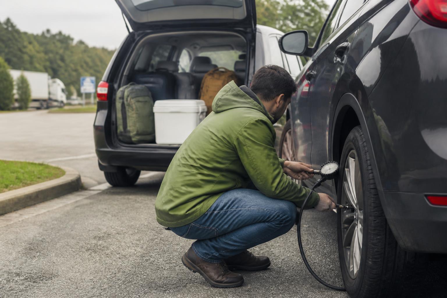 A traveler checking tire pressure while packing for a flexible road trip.