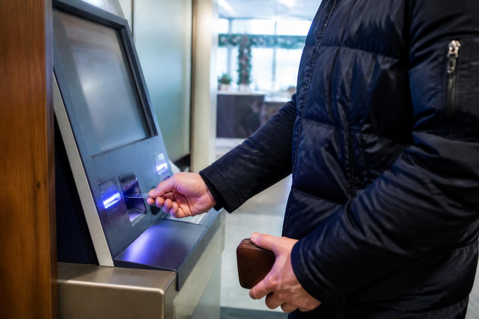 A borrower making an extra card payment at a bank kiosk.