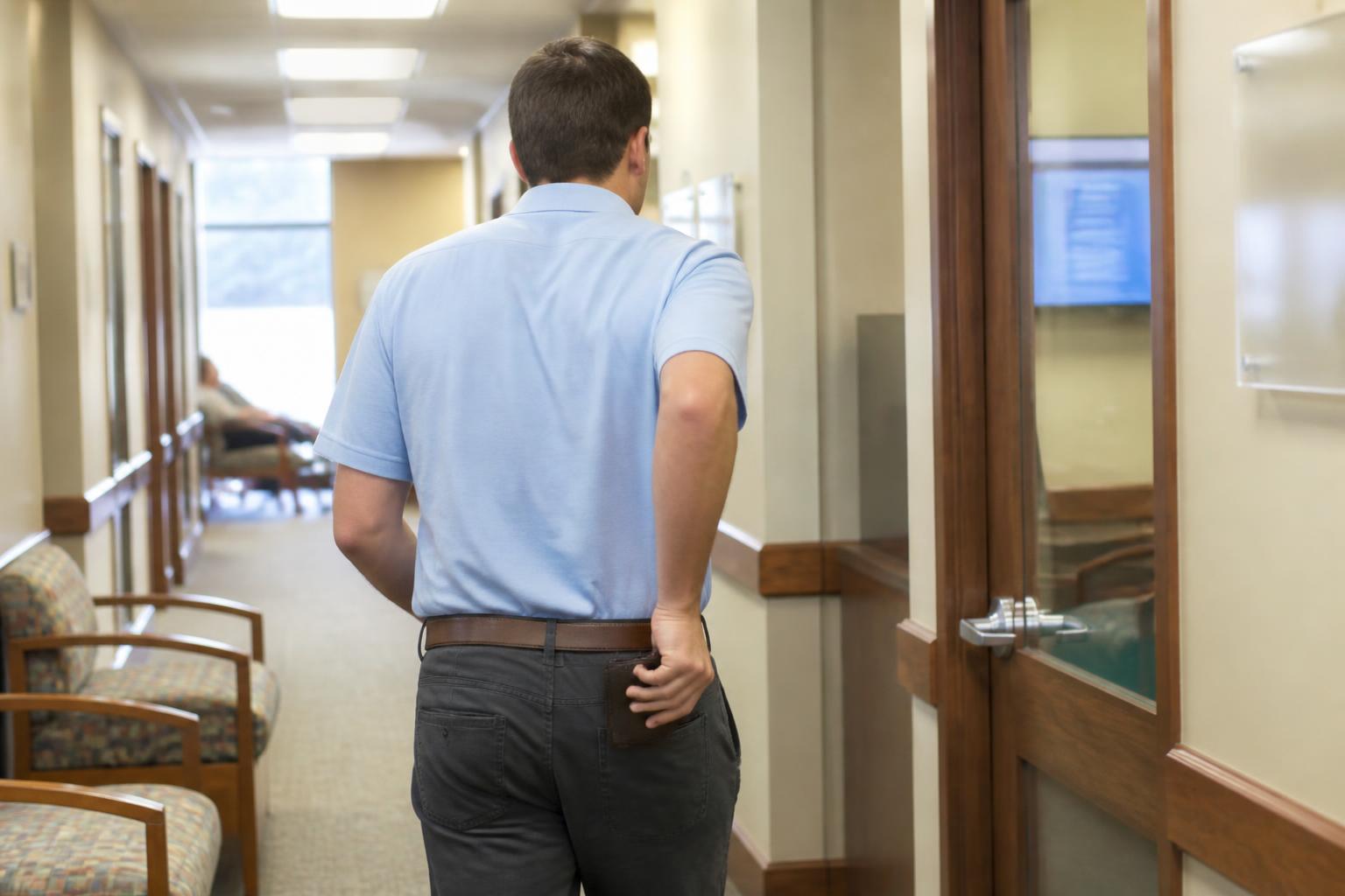 A borrower leaving a credit union loan office after a debt review.