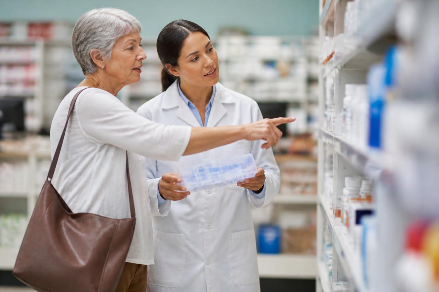 An older adult comparing medication options in a pharmacy.