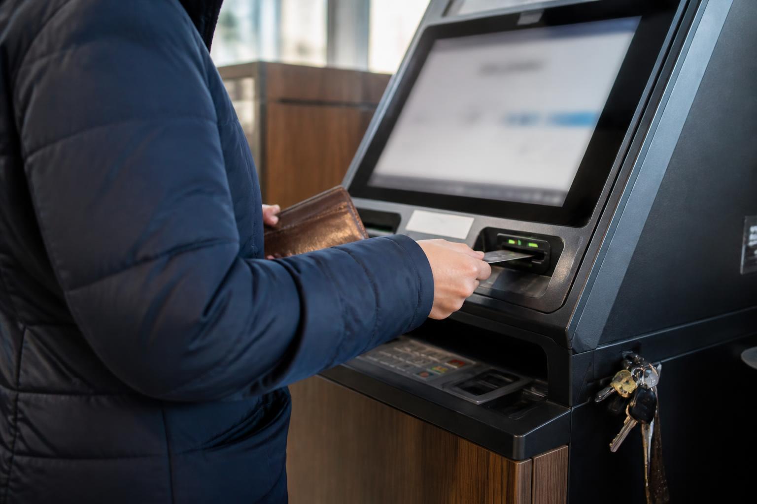 A borrower making an extra payment at a credit-union kiosk.